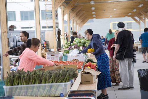 The image shows vegetable stands at the Flint Farmers Market. 