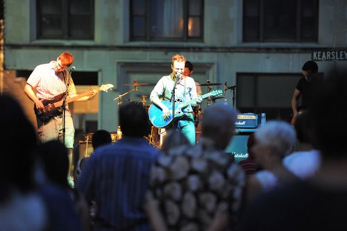 The image is of a group of people enjoying music. The music group is playing guitar. 